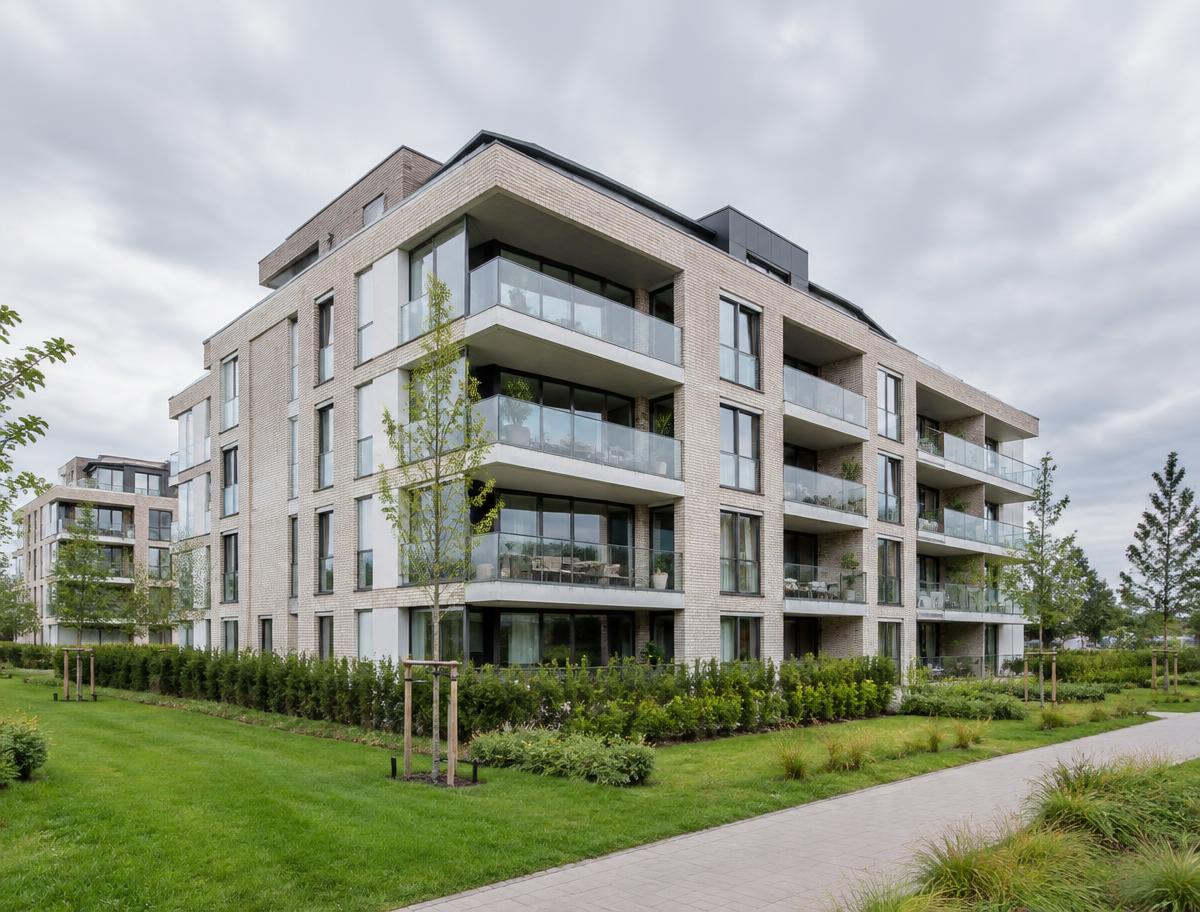 Modern appartementengebouw met glazen balkons en groene omgeving in Badhoevedorp